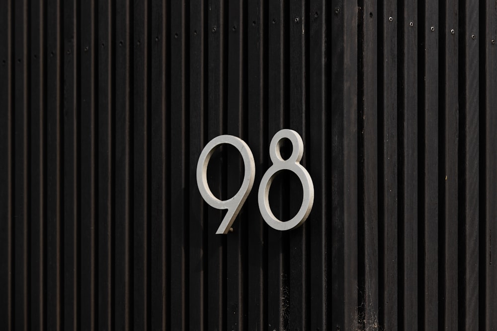 black wooden fence with white number 8