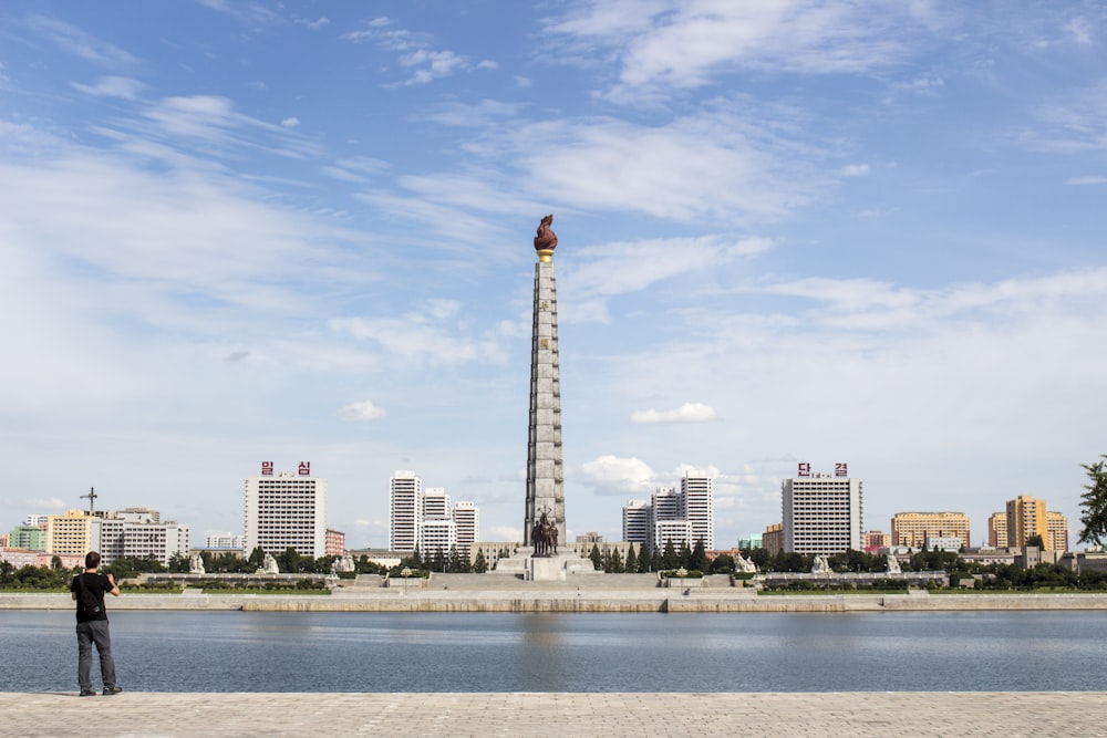 white and red tower near body of water during daytime