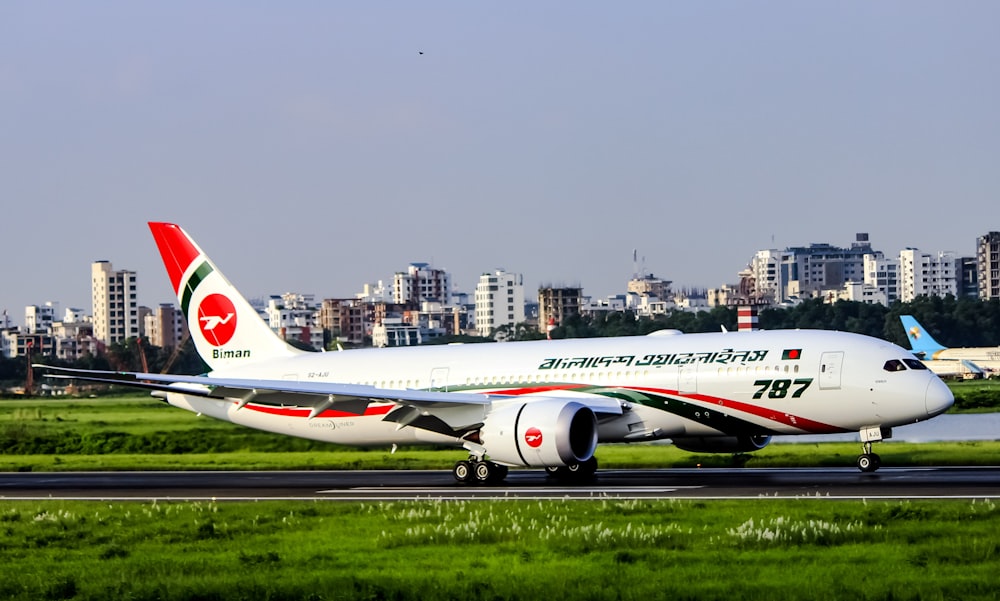 white and red passenger plane on airport during daytime