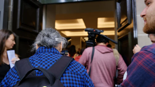 A friendly photographer setting up a camera in a bright school hallway.
