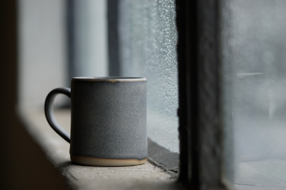 black ceramic mug on white concrete window