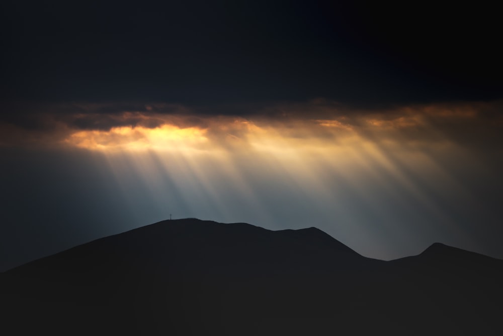 silhouette of mountain under orange sky