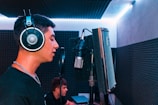Artist performing vocals in the soundproof booth with headphones on.