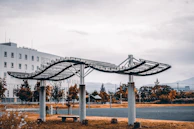 Wide shot of a contemporary metal structure supporting a wooden canopy outdoors.