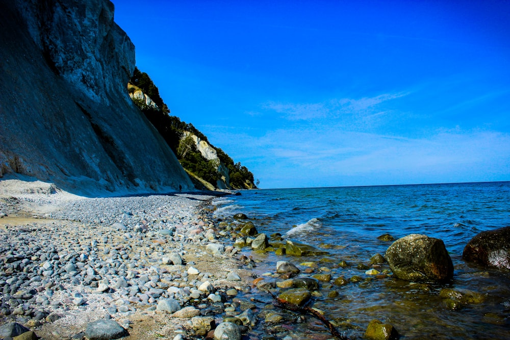 rocky shore near rocky mountain during daytime