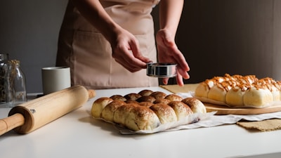 Hands sprinkling spices over roasted makhana in a kitchen setting.