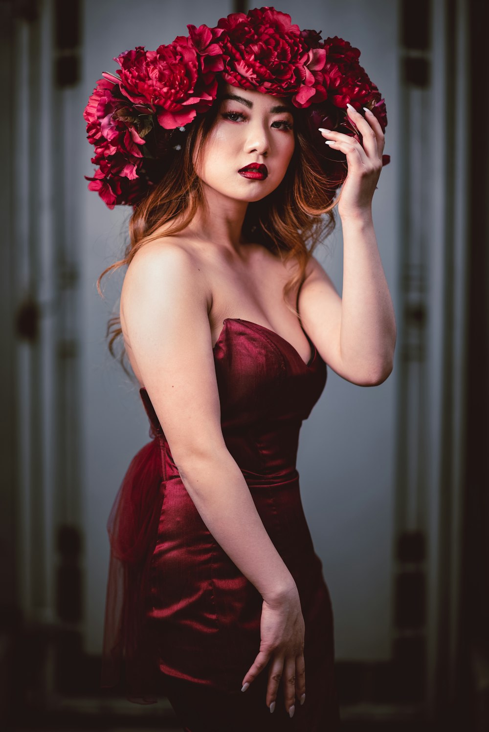 woman in red tube dress holding red flower