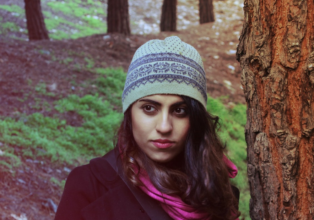 woman in white knit cap and purple jacket