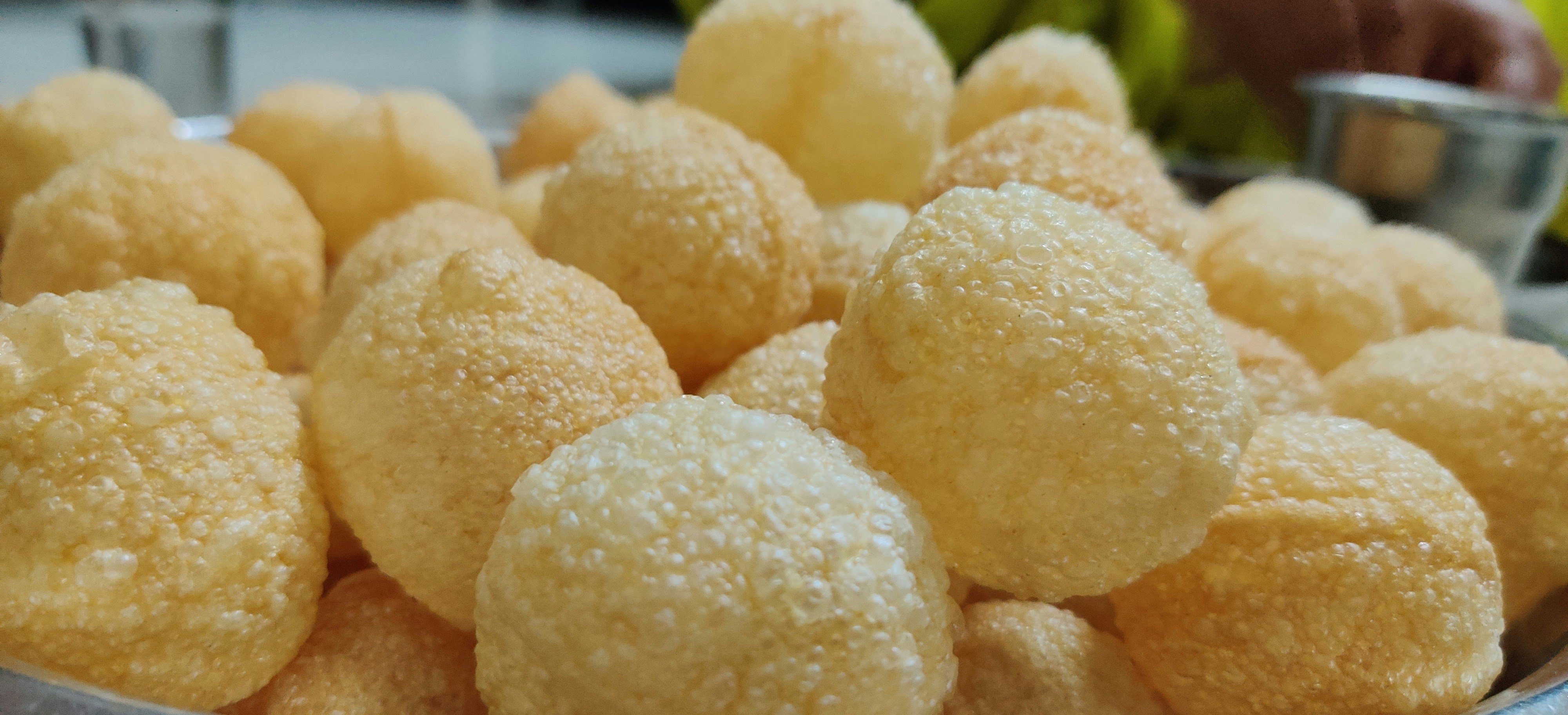 Pani puri being served at a street food counter, evening lighting, colorful garnishes