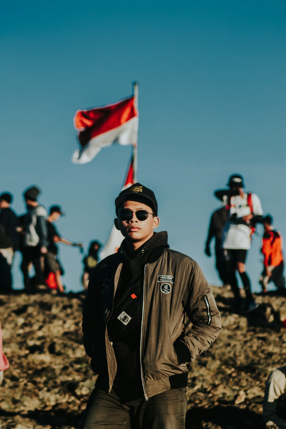 man in brown leather jacket holding red white flag