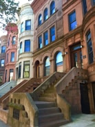 Historic neighborhood street lined with brownstones and community murals.
