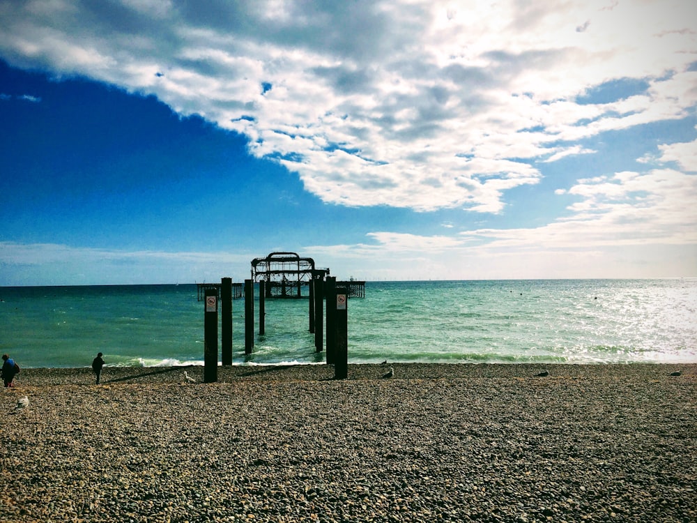 brown wooden dock on sea under blue sky during daytime