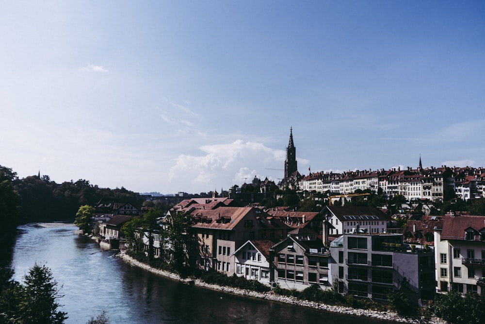 houses near body of water under blue sky during daytime