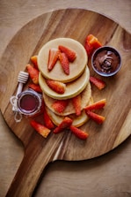 sliced strawberries and sliced strawberries on brown wooden round plate