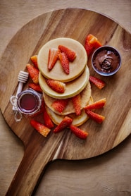 sliced strawberries and sliced strawberries on brown wooden round plate