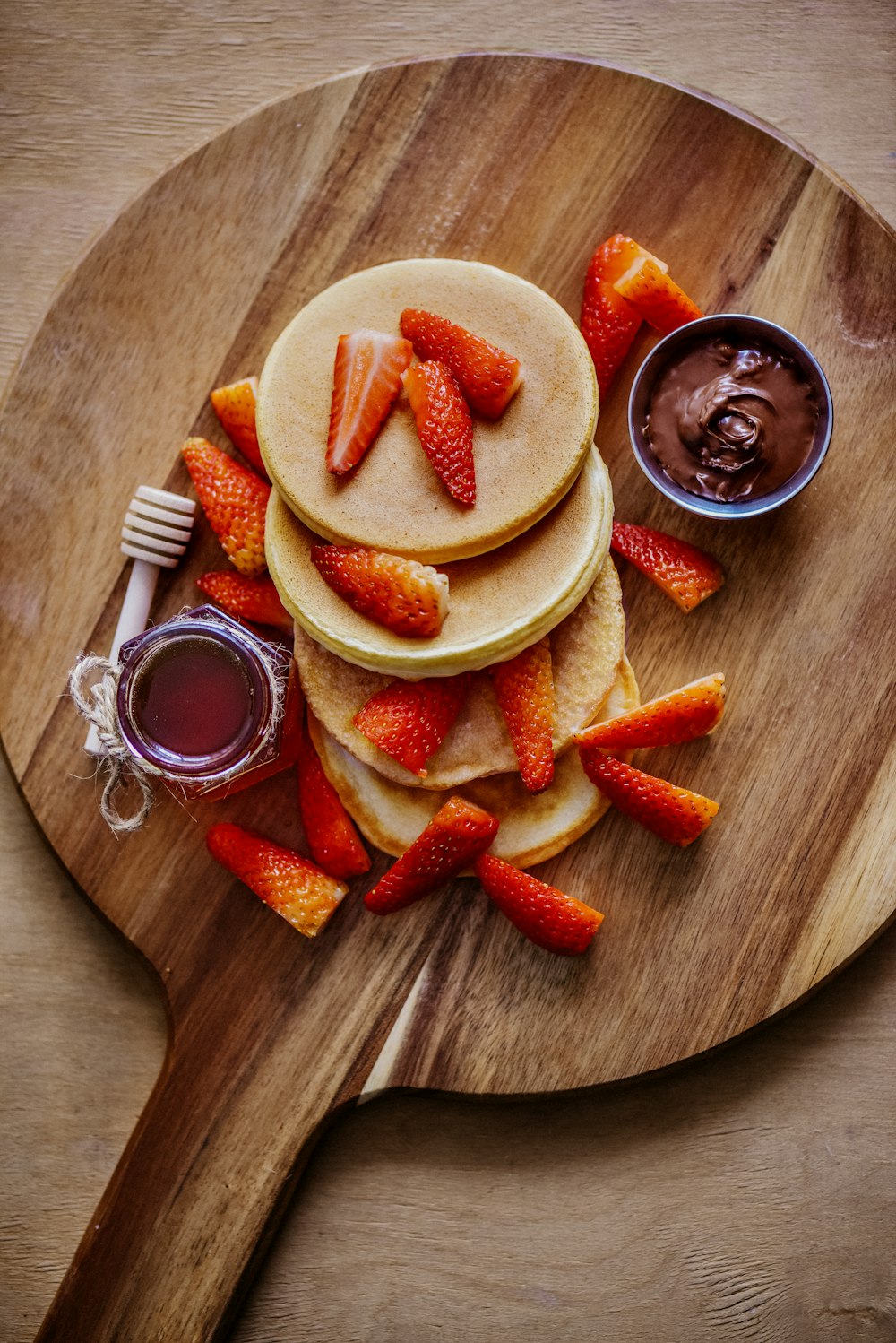 sliced strawberries and sliced strawberries on brown wooden round plate