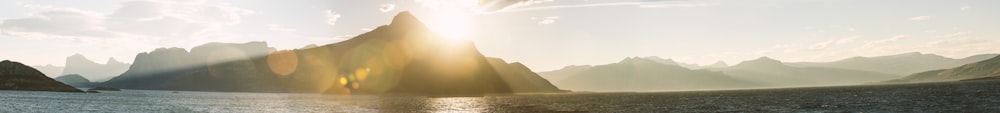 body of water near mountain during daytime