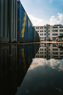 blue and white glass building near body of water during daytime