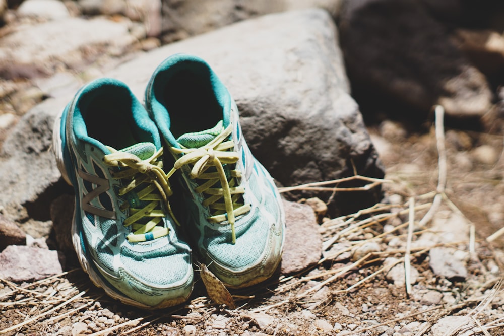 Chaussures de course vertes et noires sur roche brune