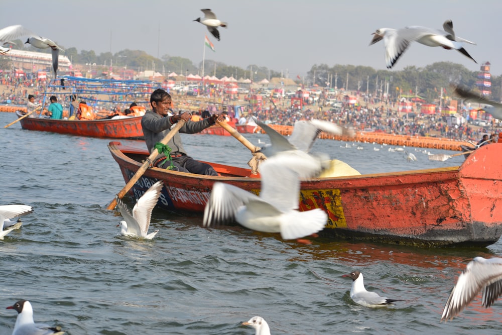 man in green shirt sitting on brown boat during daytime