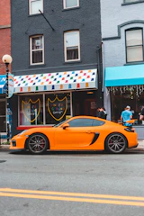 A vibrant electric cart parked on a city street with a young person handing over sneakers for cleaning.