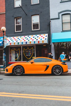 A vibrant electric cart parked on a city street with a young person handing over sneakers for cleaning.