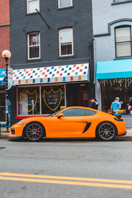 A vibrant electric cart parked on a busy urban street with sneakers displayed nearby.