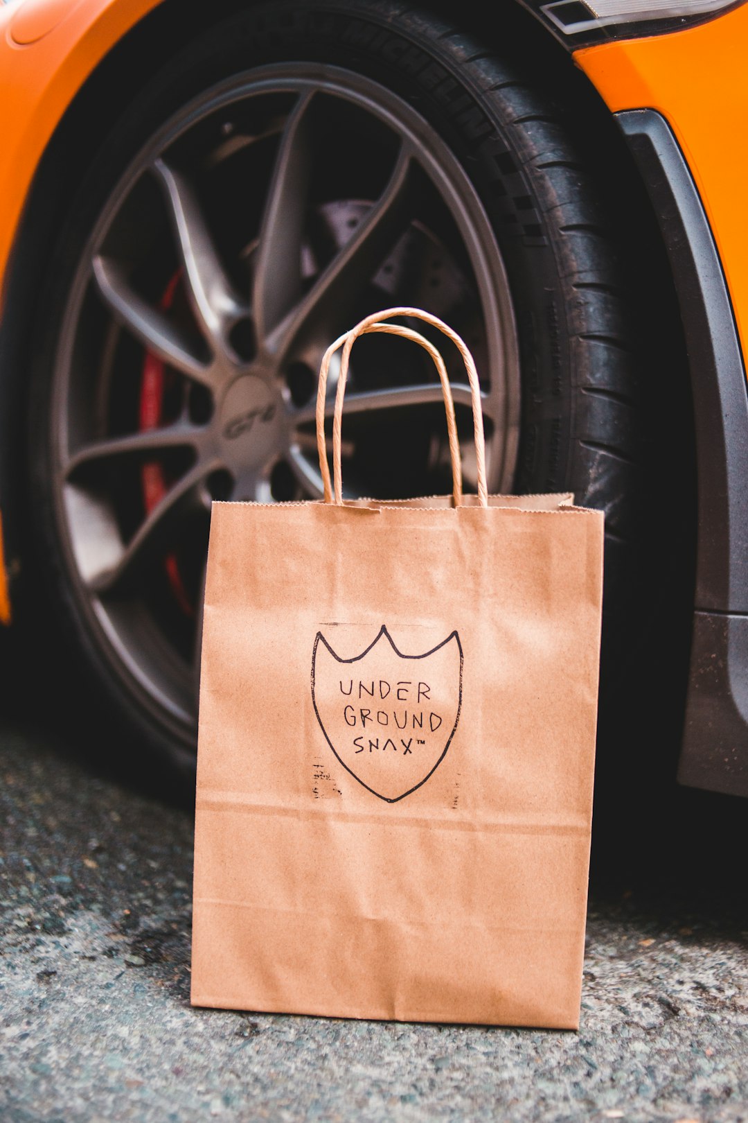 brown paper bag on black car wheel