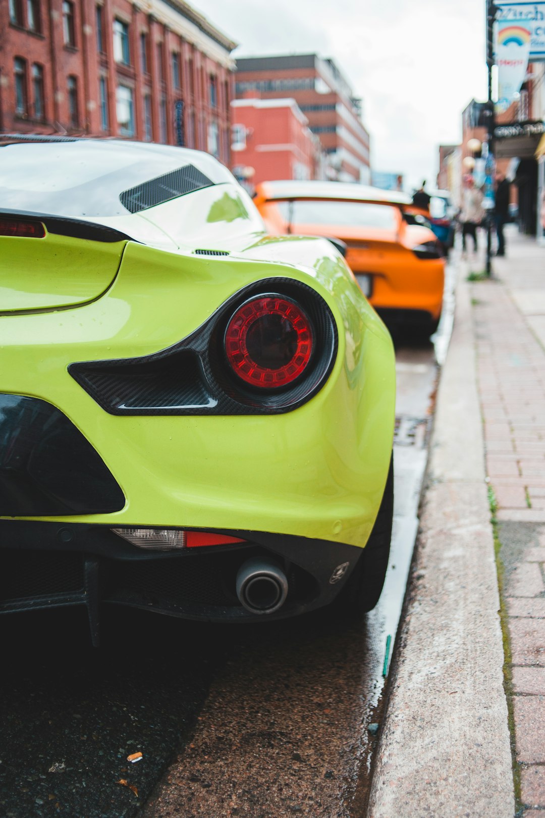 green lamborghini aventador parked on sidewalk during daytime