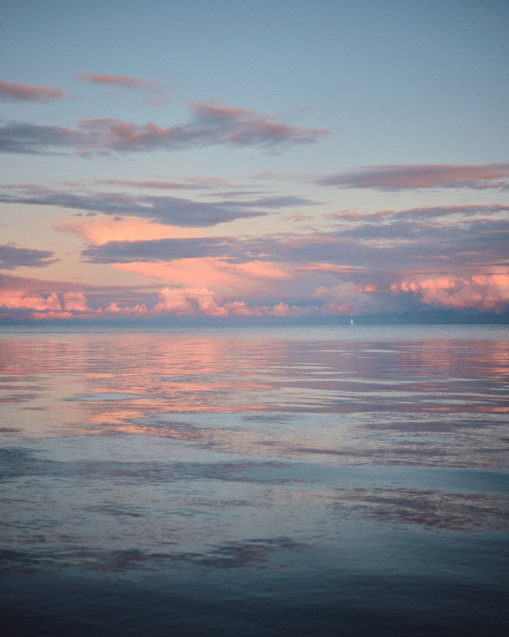 body of water under cloudy sky during sunset