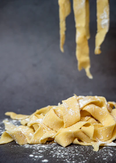 Fresh handmade pasta dusted with flour on a wooden board