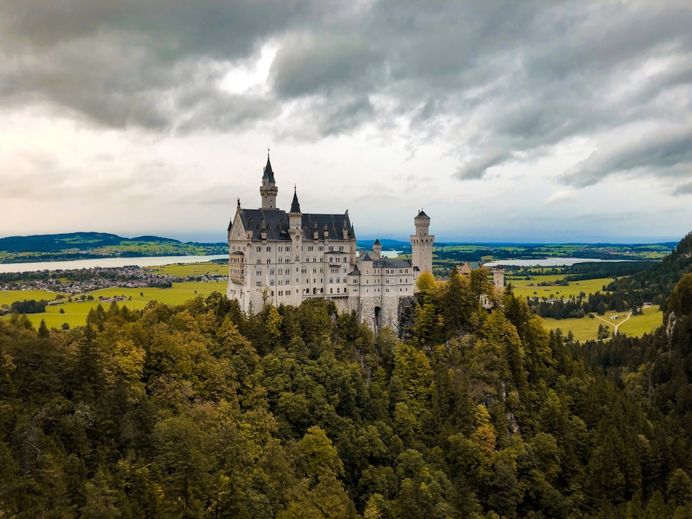 Weiße Betonburg auf einem Hügel unter bewölktem Himmel tagsüber