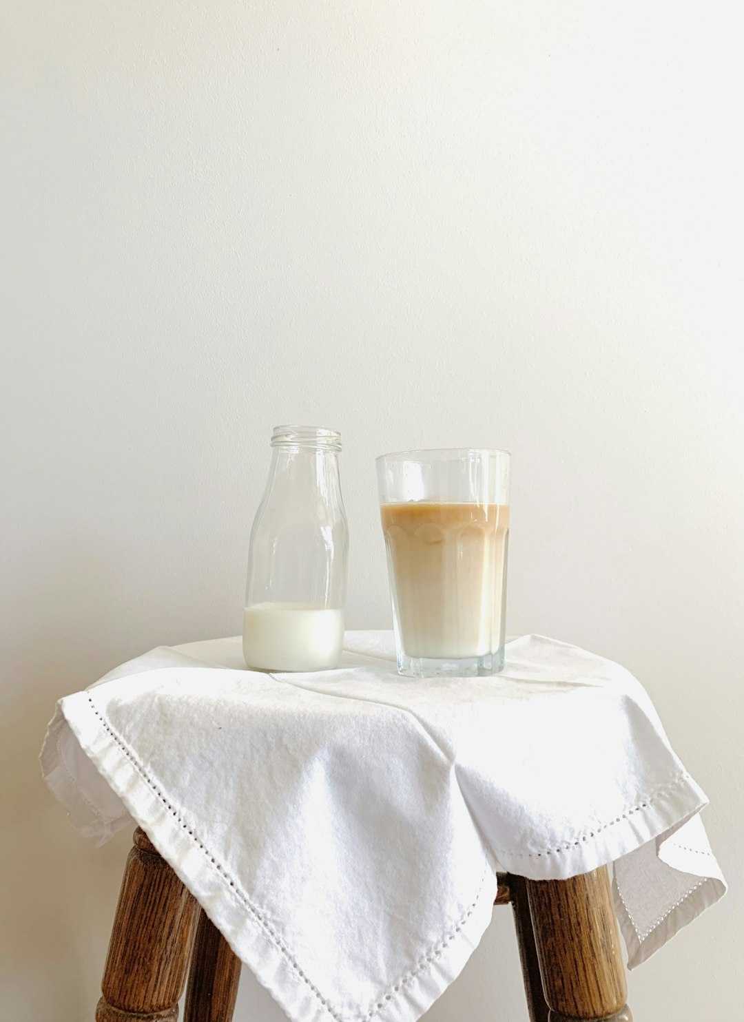  clear glass bottle on white textile tablecloth