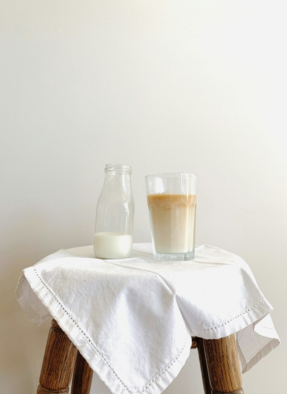 clear glass bottle on white textile