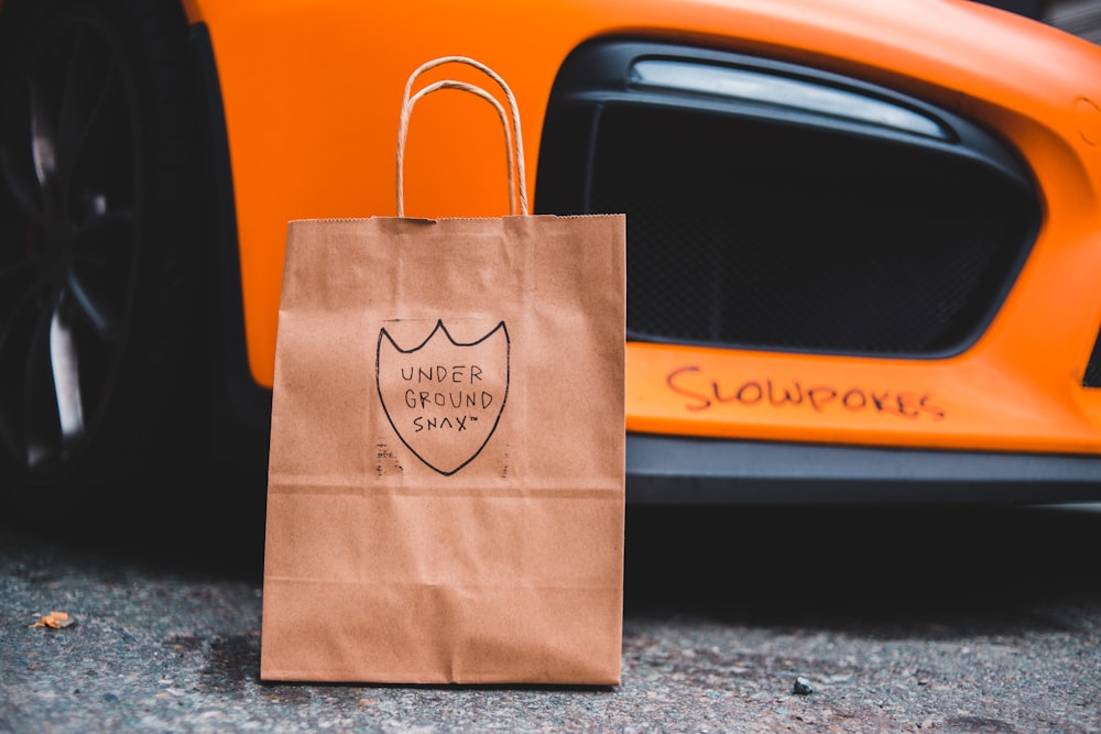 brown paper bag on black car door