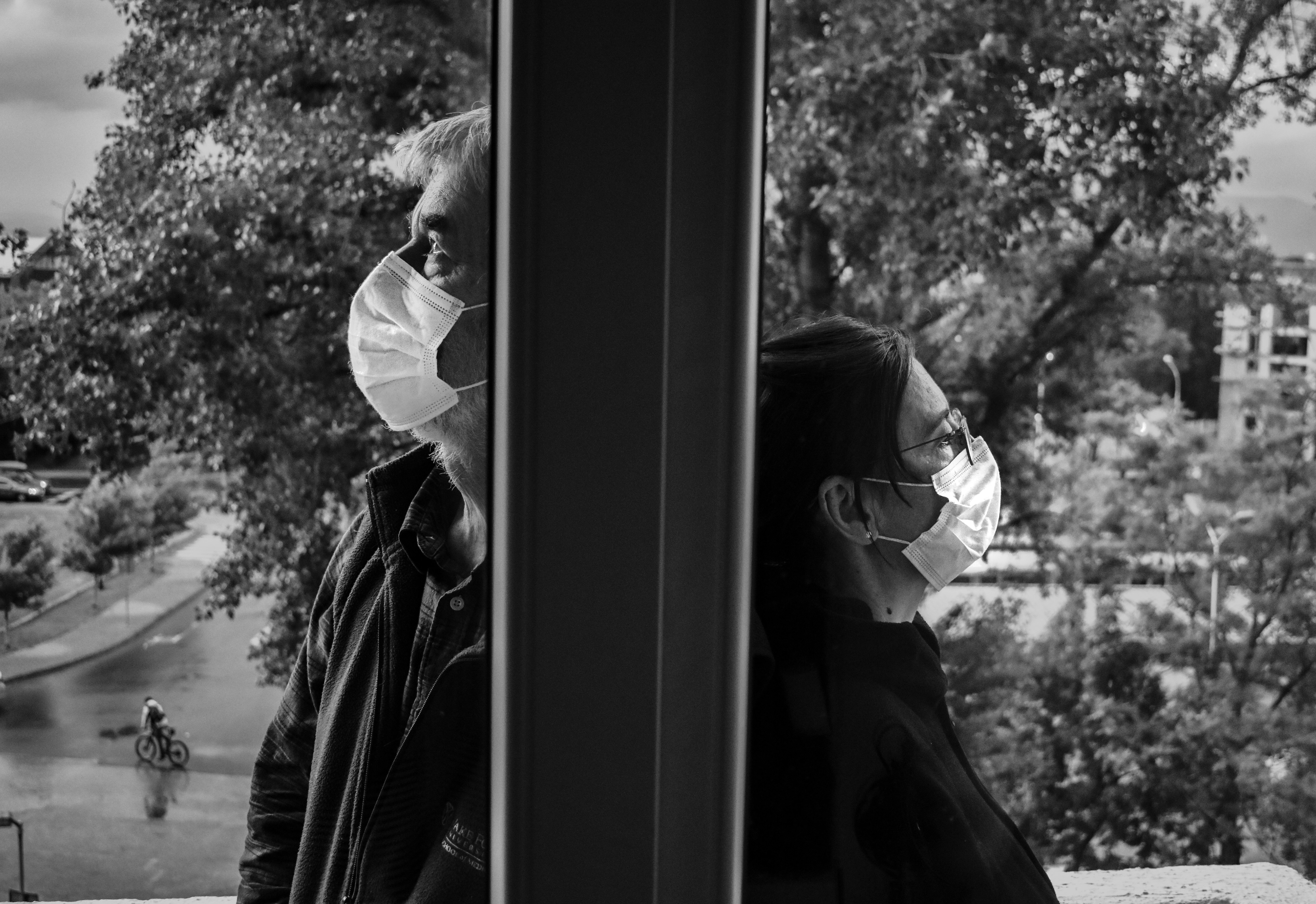 man and woman kissing near window