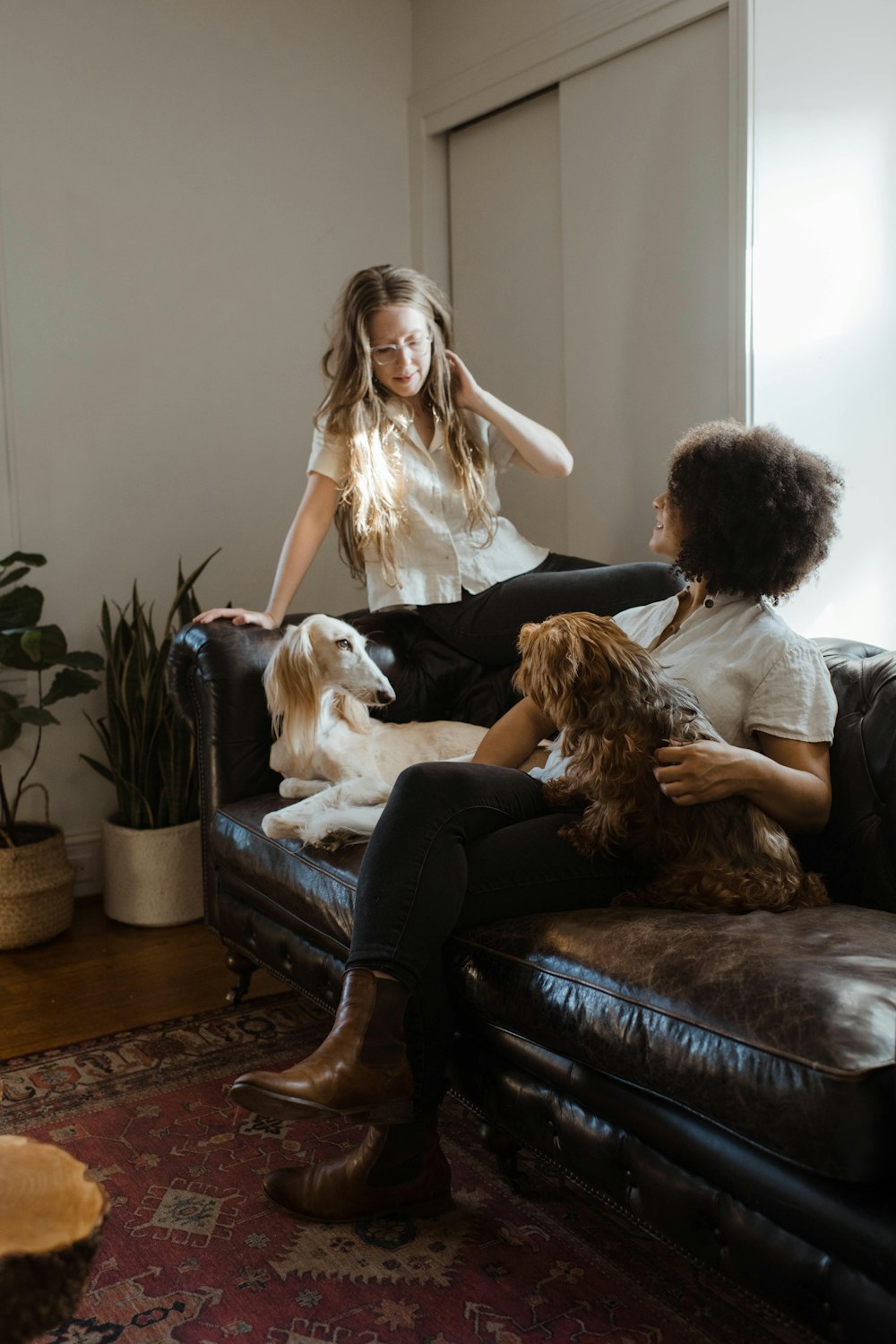 woman in white shirt sitting on black leather couch