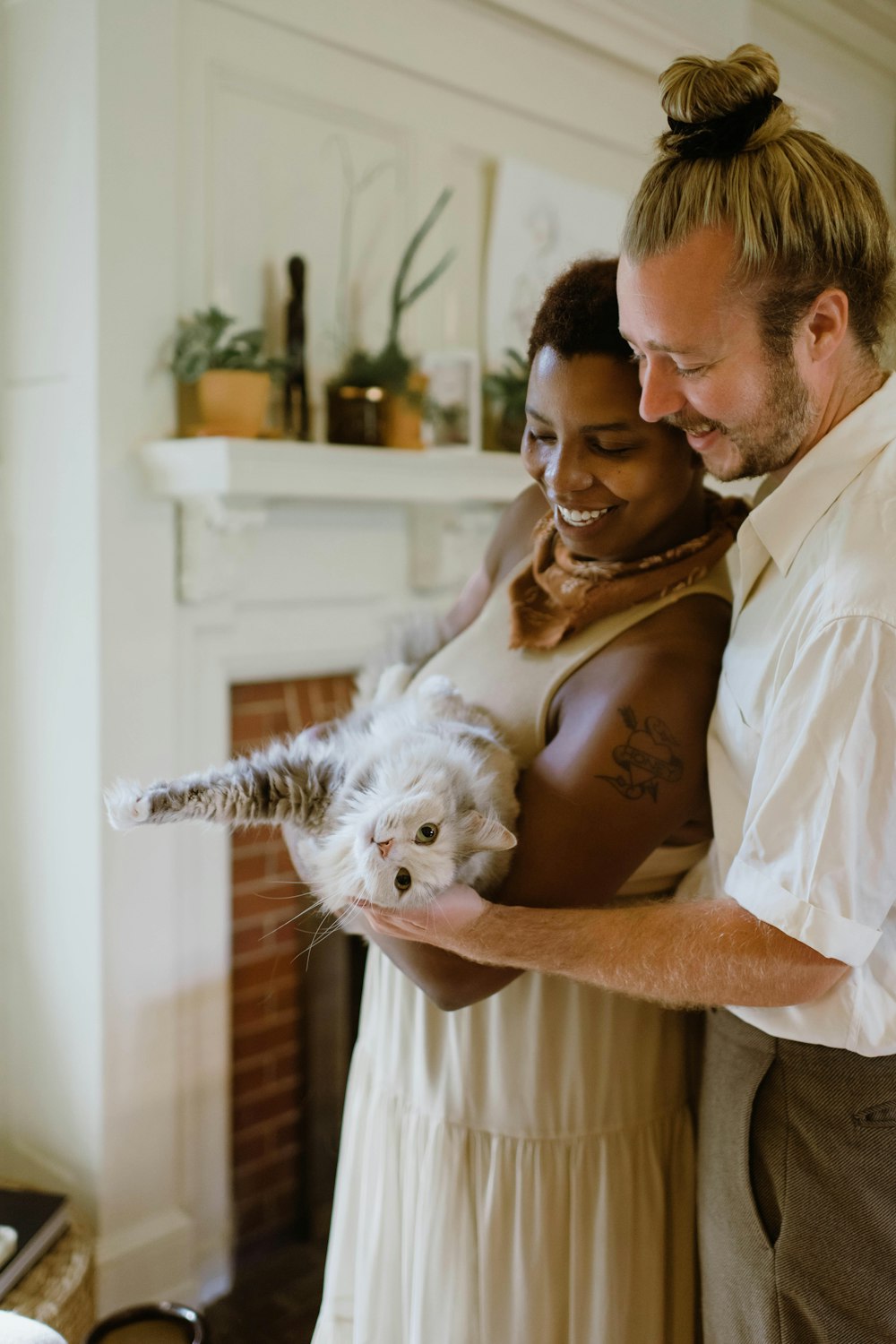 Homme en chemise blanche boutonnée portant un chat blanc