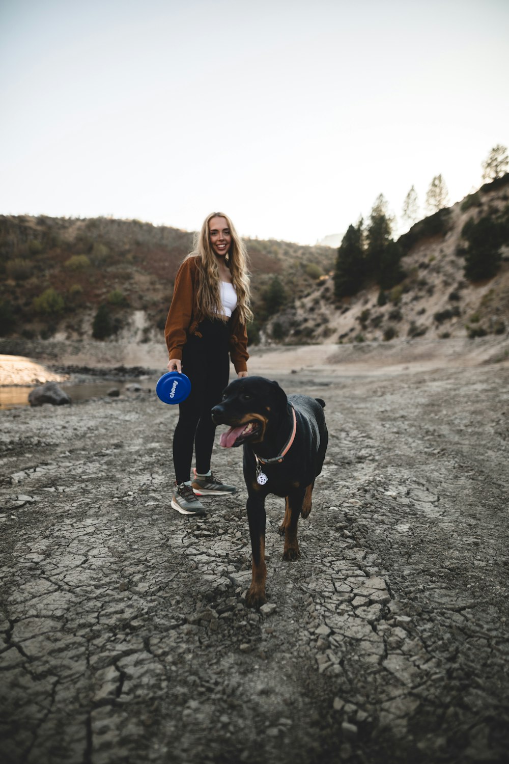 woman in black t-shirt holding blue and white ball