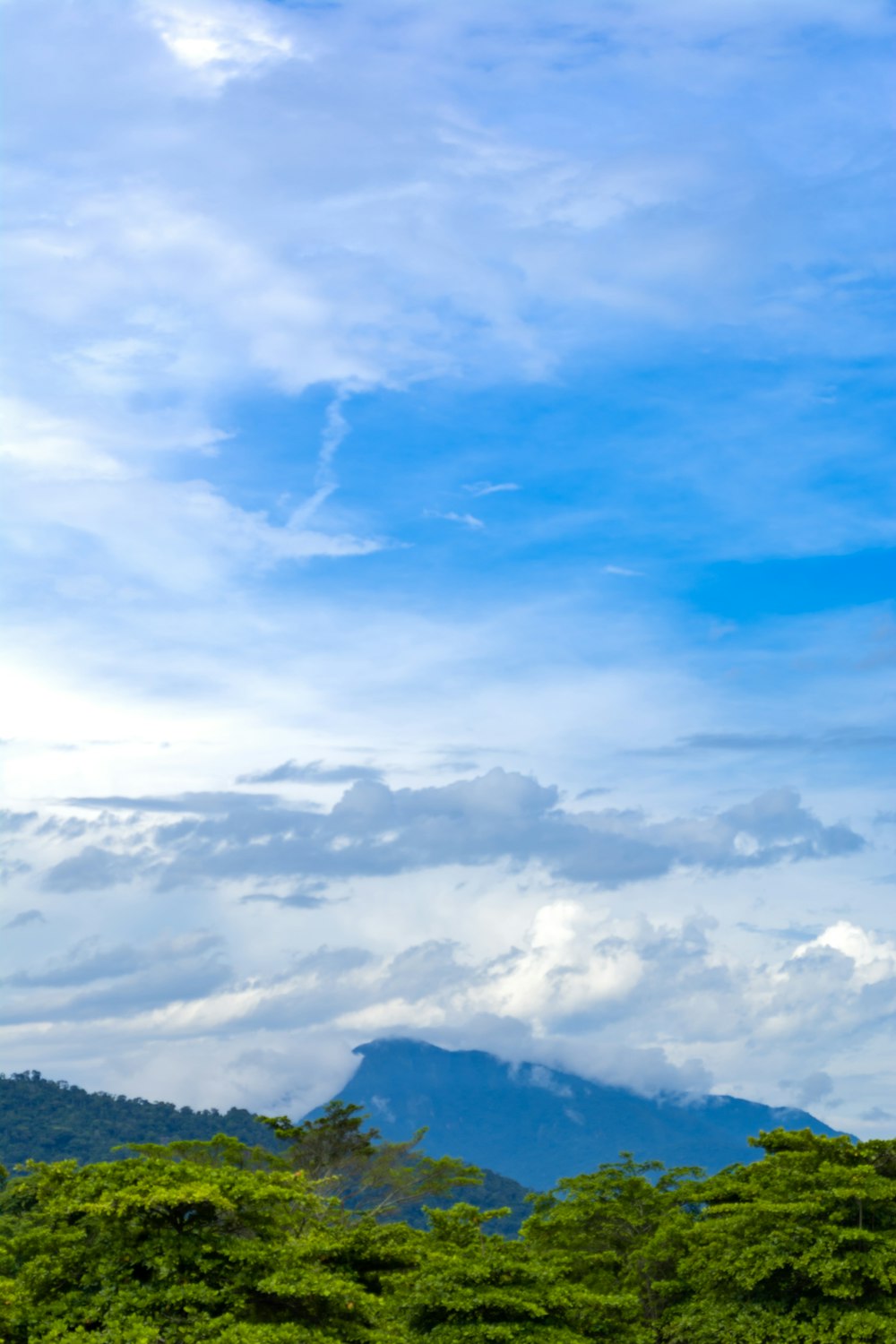 white clouds over green mountains during daytime