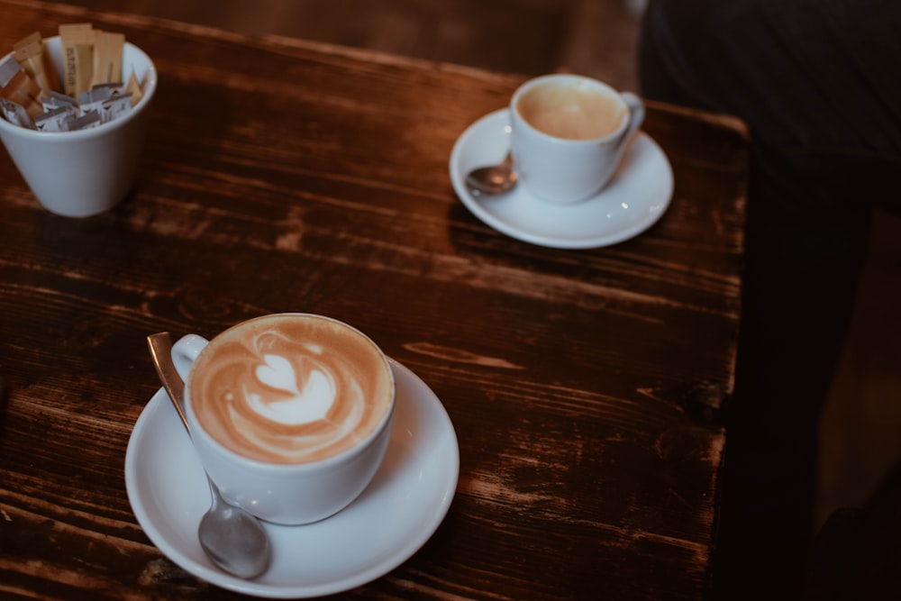 white ceramic cup with saucer on brown wooden table