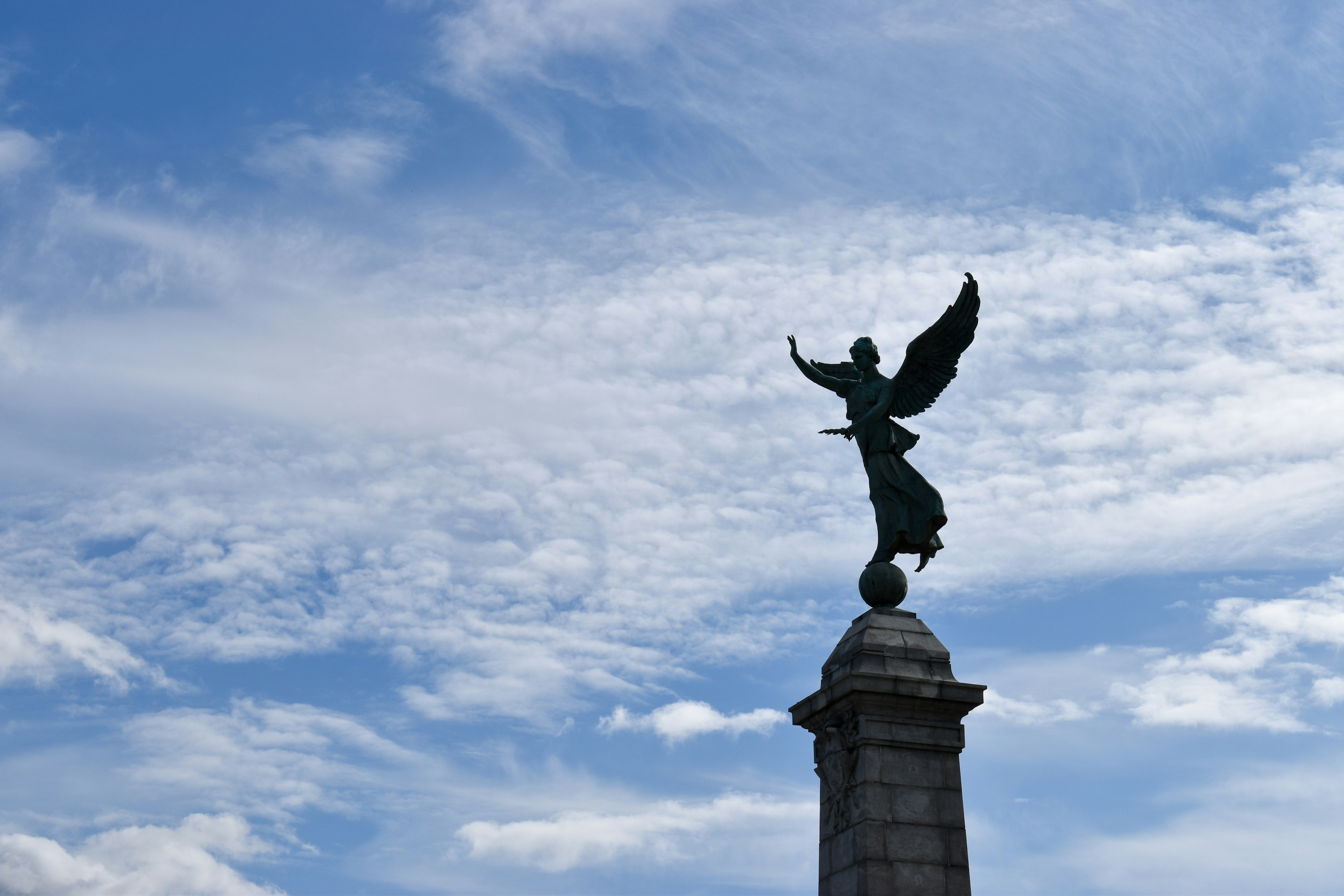 black statue under white clouds during daytime