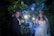 A joyful bride and groom standing next to glowing marquee letters spelling their initials at twilight.