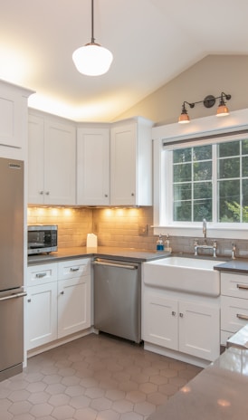 white wooden kitchen cabinet and white pendant lamp