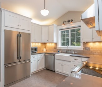 white wooden kitchen cabinet and white pendant lamp