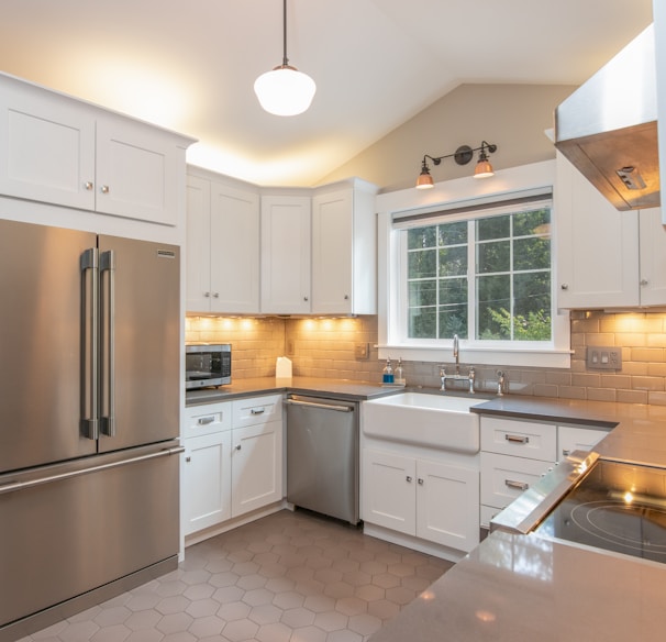 white wooden kitchen cabinet and white pendant lamp