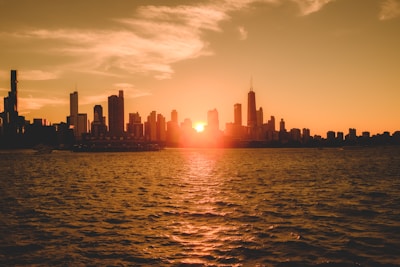 A cinematic still of a sunset cityscape, capturing warm golden light reflecting off glass buildings.