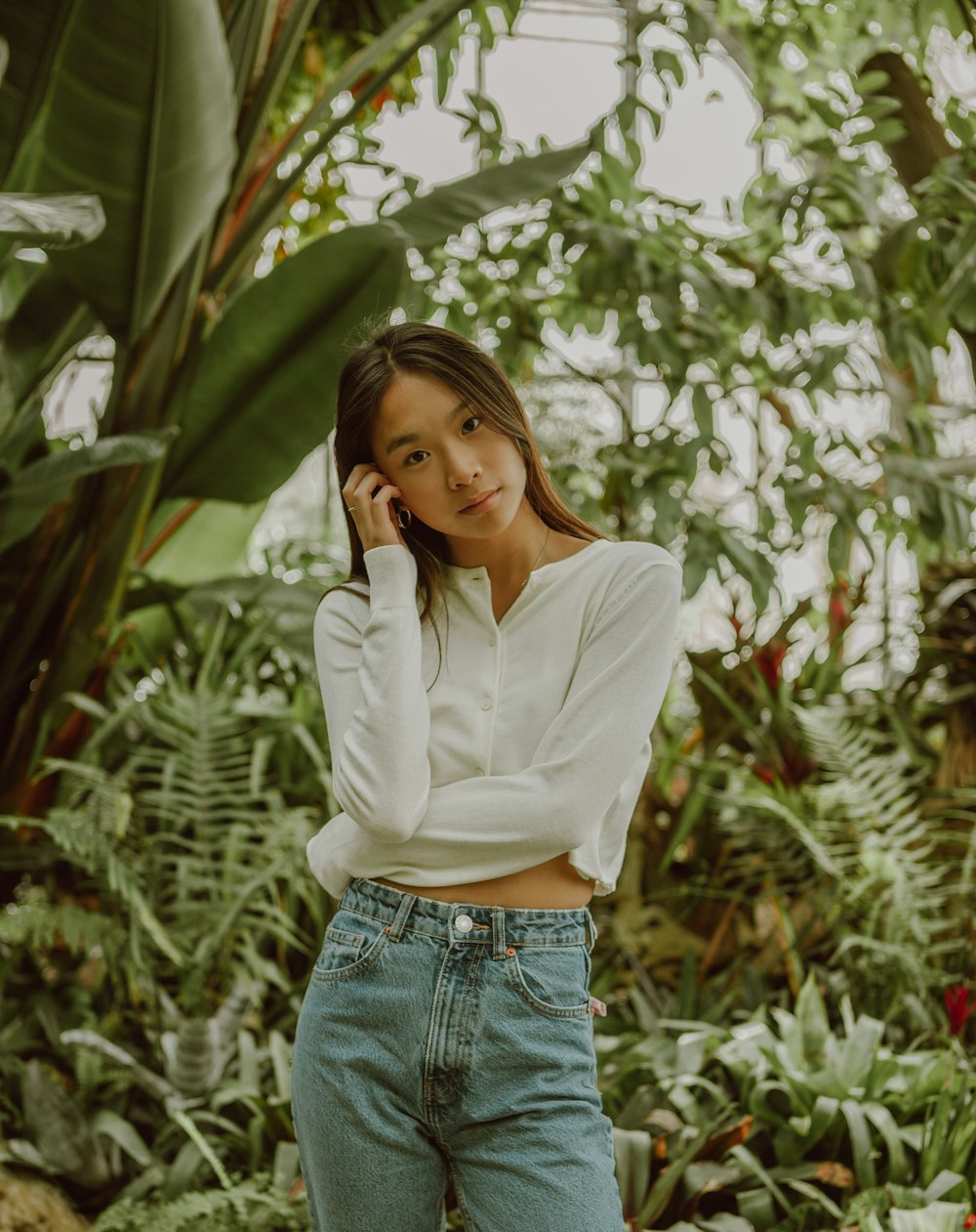 Woman in white dress shirt and blue denim jeans standing near green plants  during daytime photo – Free Canada Image on Unsplash
