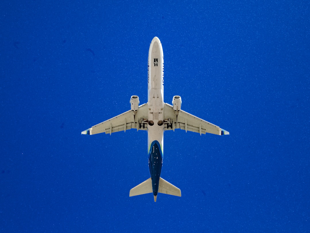 white and blue airplane in flight,