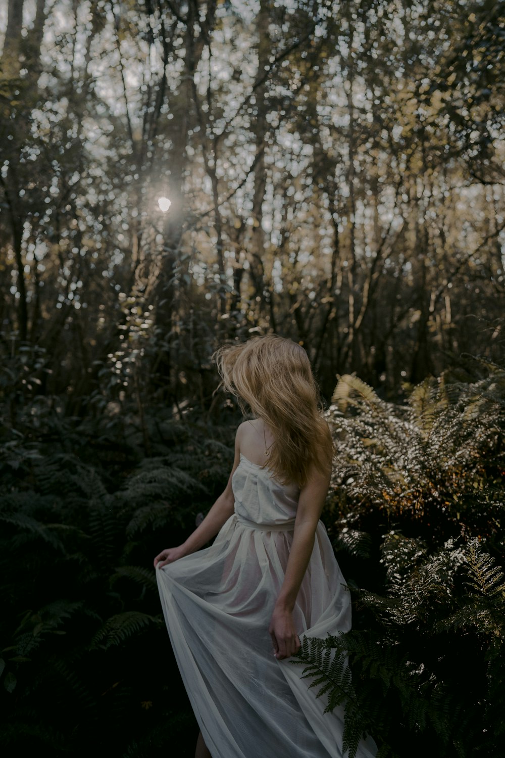 woman in white dress sitting on green grass during daytime